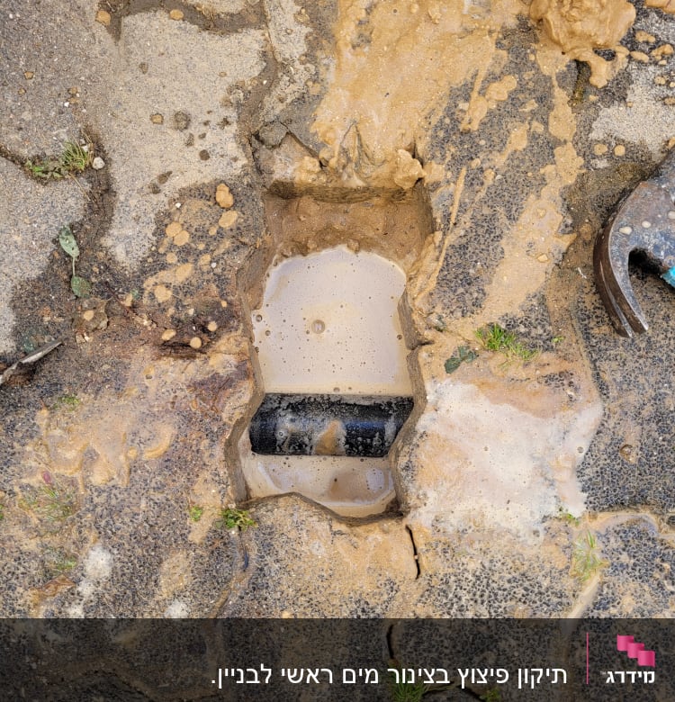 צינור שבור עם מים ובוץ על הקרקע
